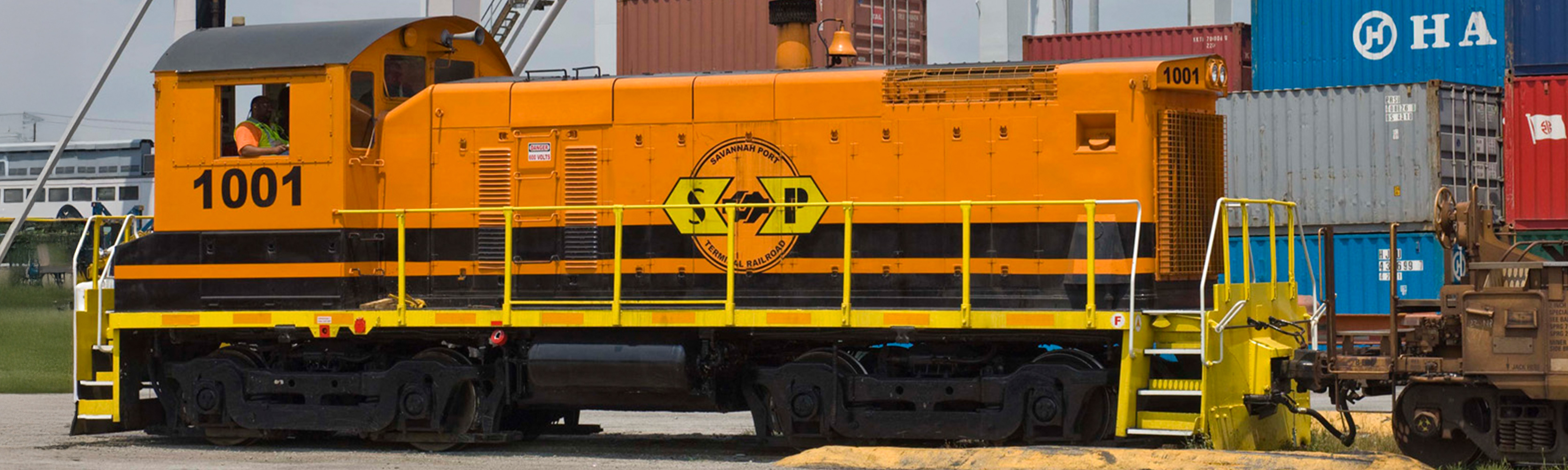 Train at a port with the ocean in the background