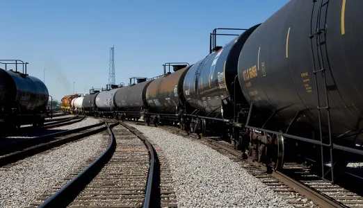 Tracks in a train yard with many tank cars