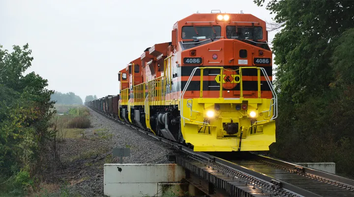 Front-facing view of a train pulling freight railcars on an elevated track