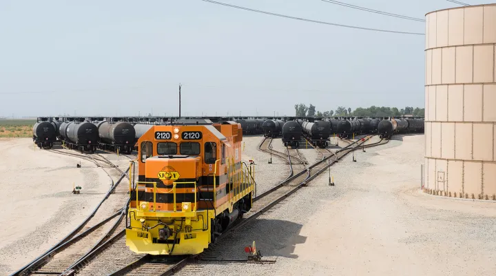 Train leaving a railroad yard full of tank cars